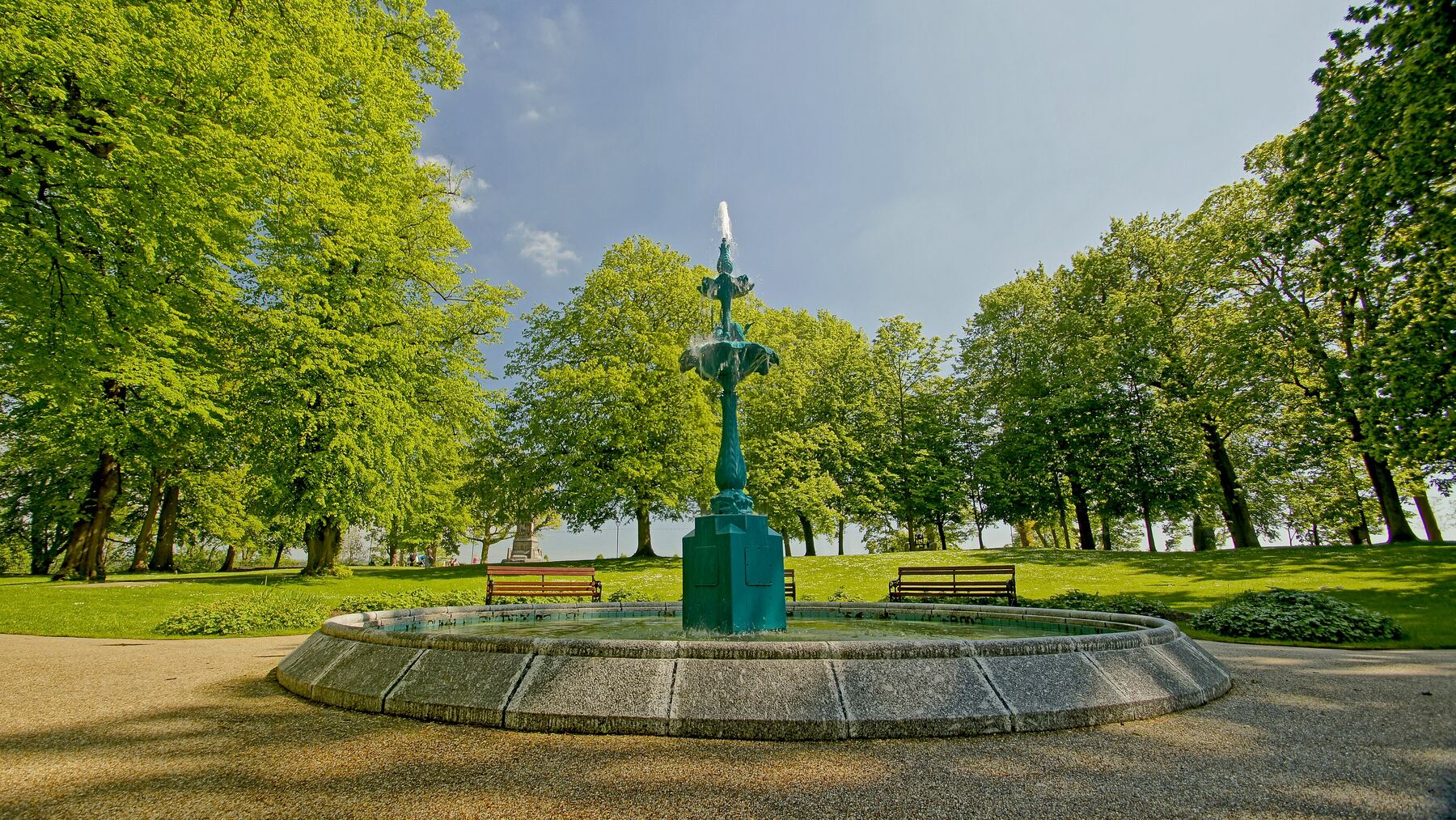 The fountain in Castle Gardens, Lisburn, surrounded by trees in summer